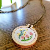 closeup of pink & yellow hand embroidered pendant